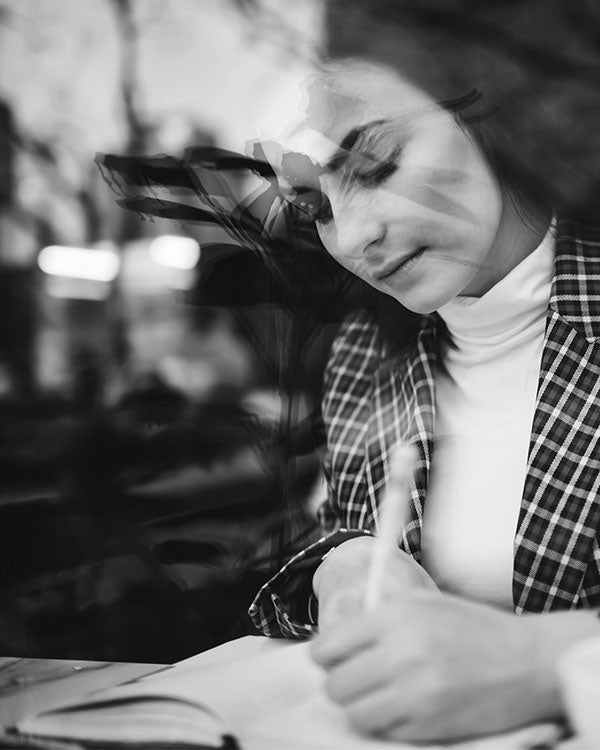 Woman in cafe journaling in her notebook
